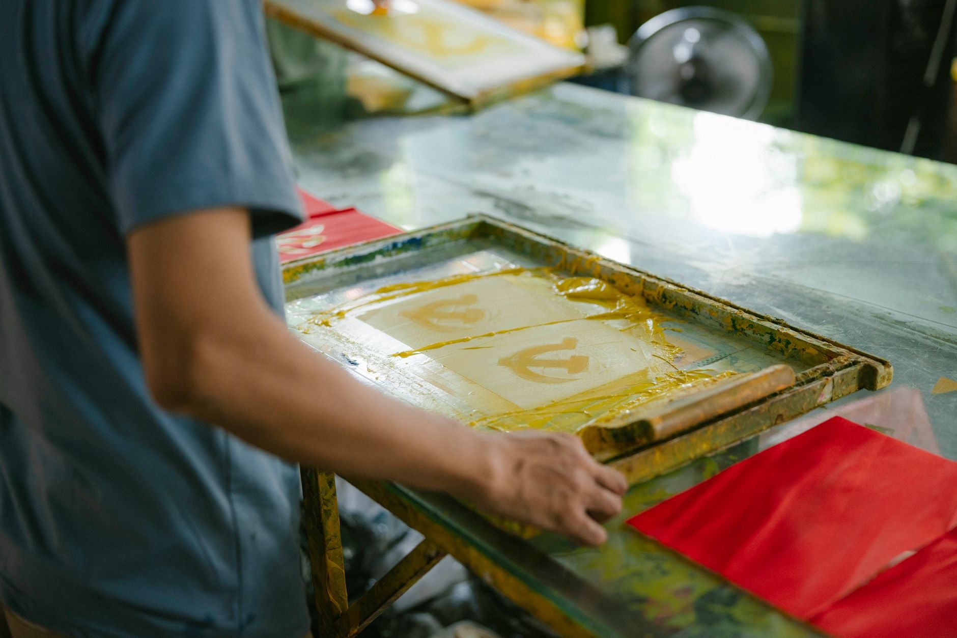 Artisan appliquant une encre colorée pour l'impression d'un visuel textile en atelier