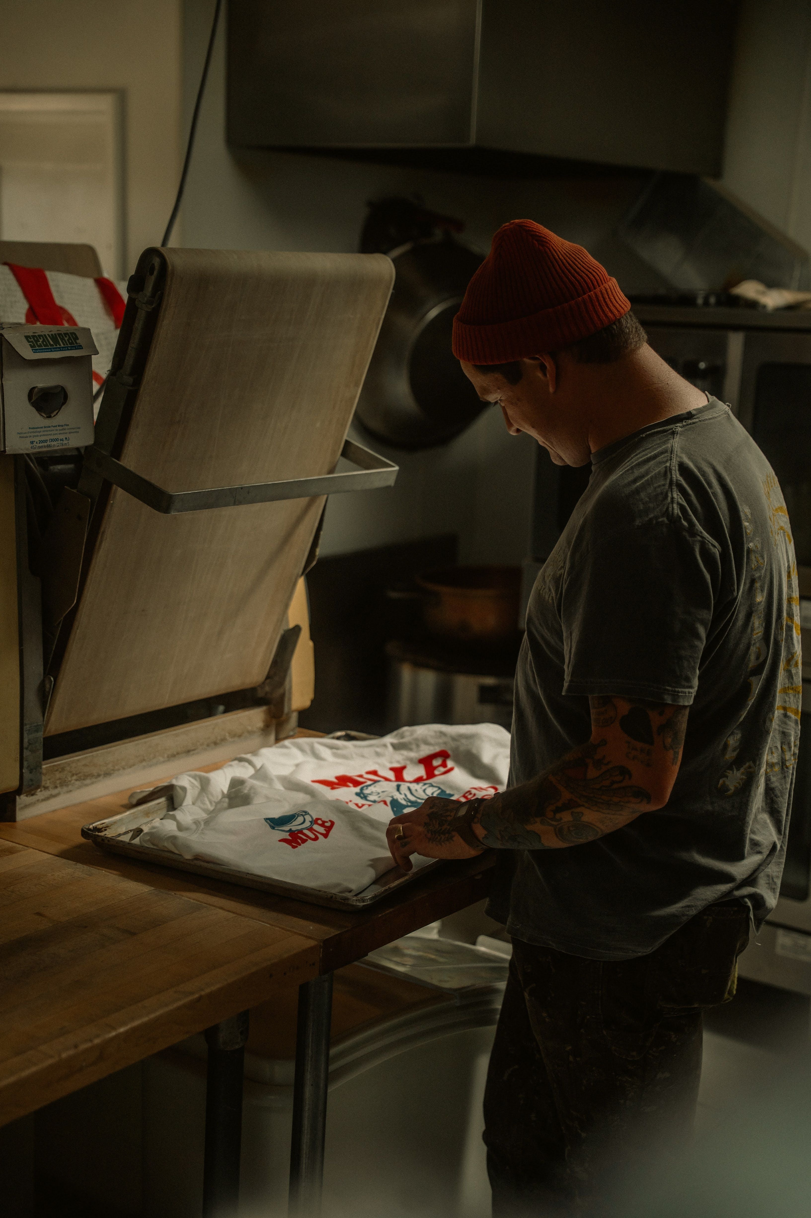 Presse à chaleur appliquant un transfert DTF personnalisé sur textile