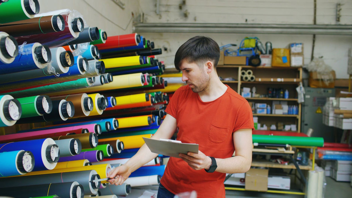 Rouleaux de films de marquage stockés dans un atelier textile, où le coût se calcule au mètre