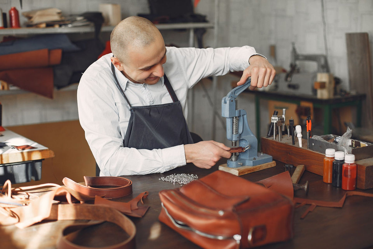 Artisan utilisant une presse d'établi manuelle dans un atelier équipé (photo d'illustration)