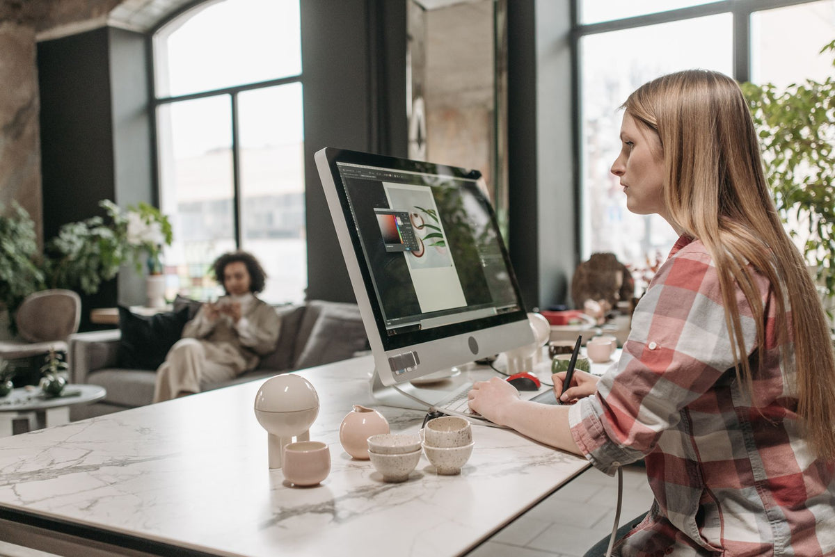 Graphiste travaillant sur un visuel à l'écran avec une tablette graphique