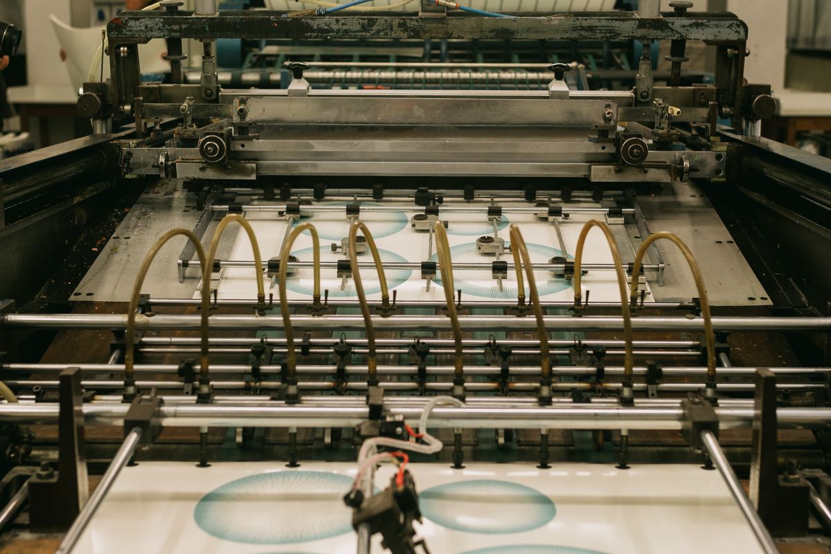 Presse d'impression industrielle en sortie de feuilles imprimées, étape de production d'une planche