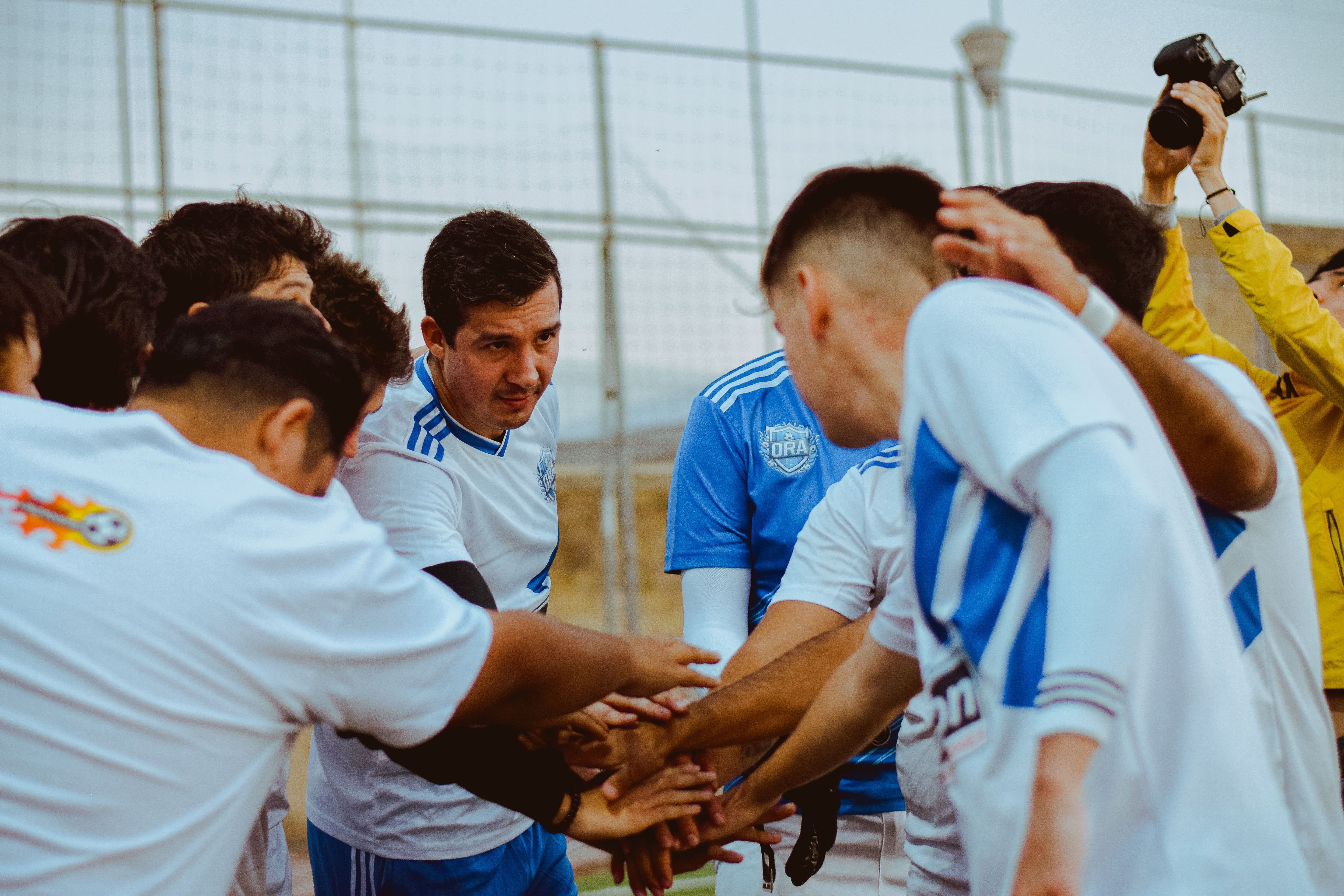 Équipe de football amateur en maillots personnalisés célébrant en cercle après un match