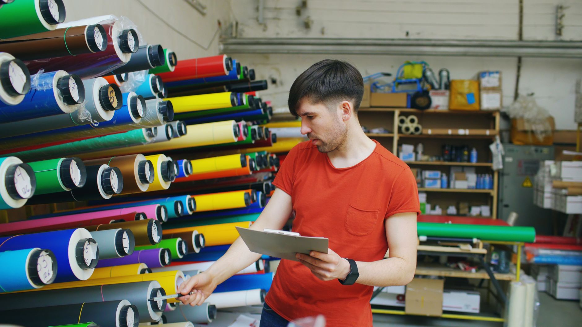 Professionnel vérifiant des rouleaux de film transfert DTF de différentes couleurs en atelier