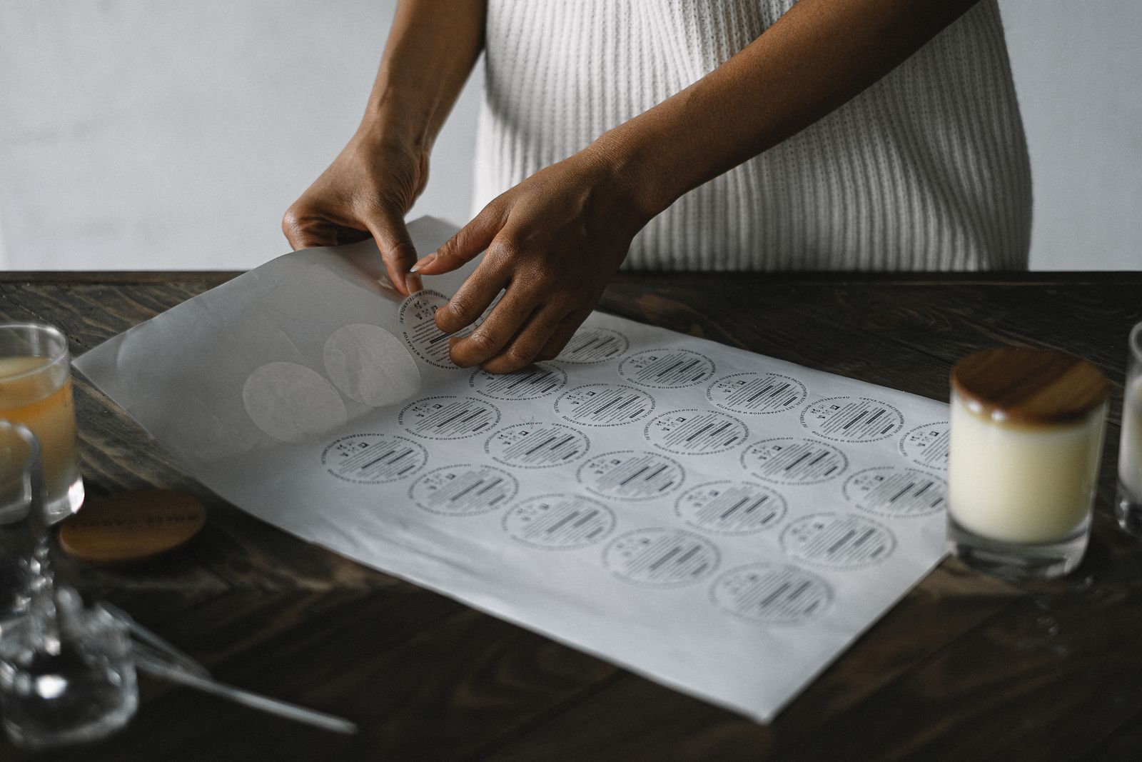 Feuille de stickers transferts prédécoupés dont on décolle un motif, prêt à poser sur un verre ou un bocal en verre