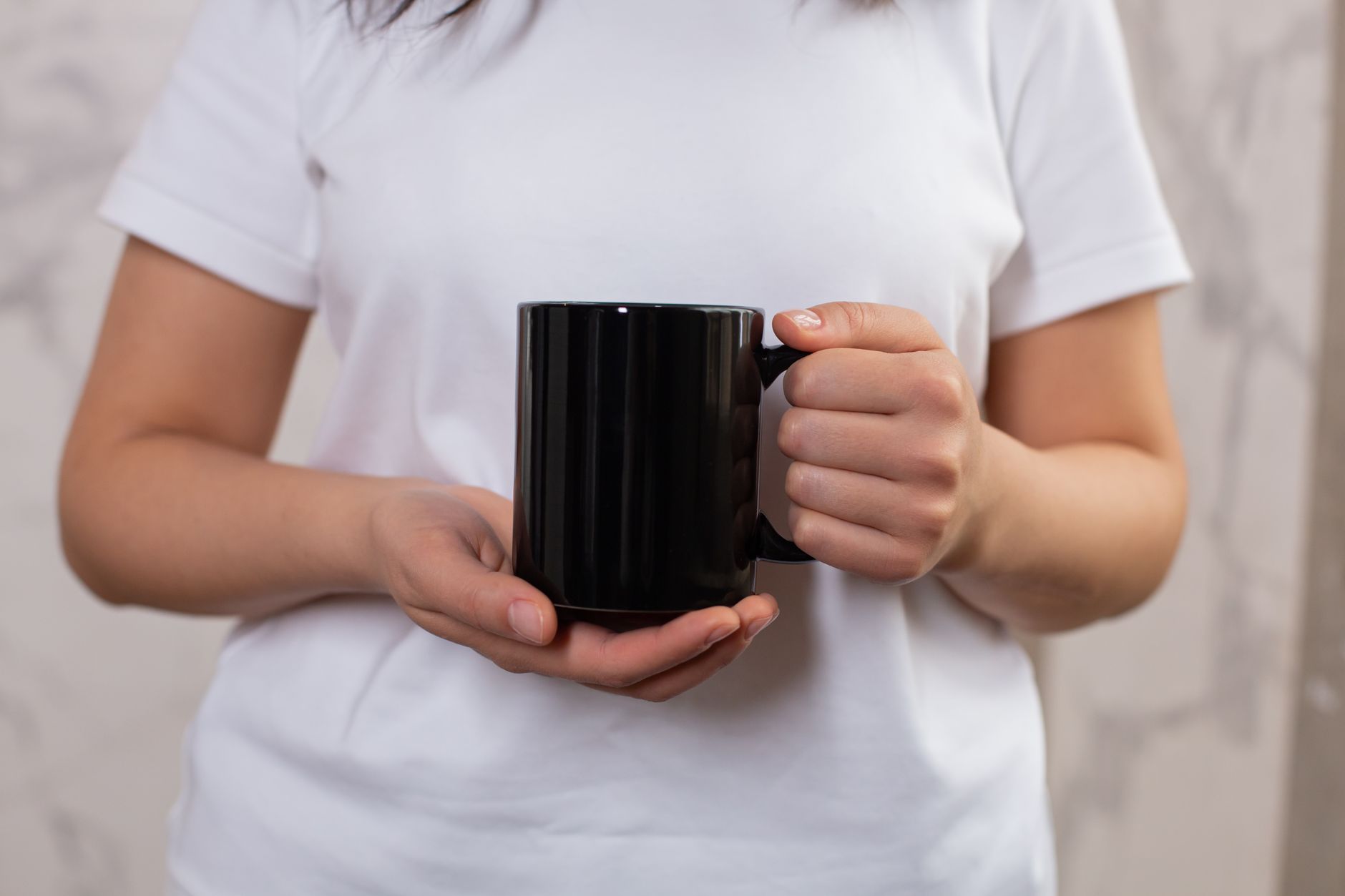 Mains appliquant un sticker DTF UV sur une tasse blanche personnalisée