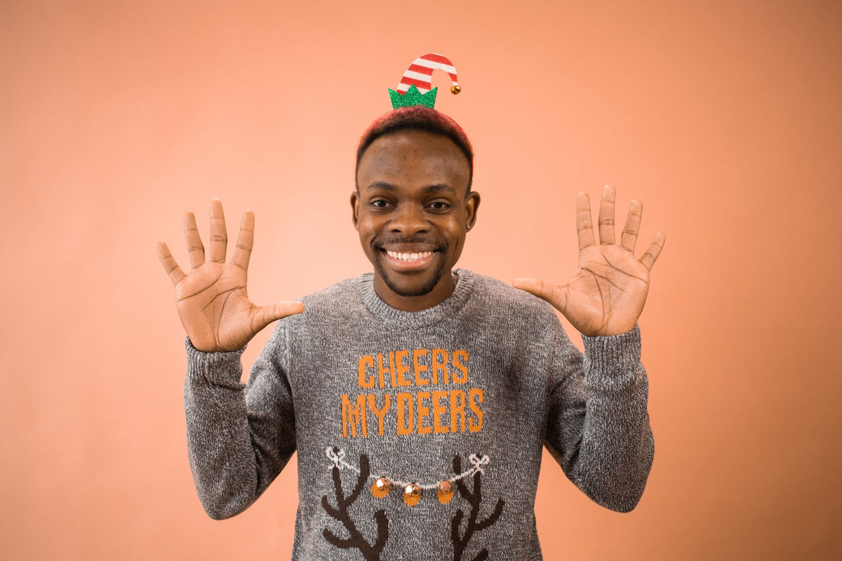 L'esprit kitsch assumé d'un pull moche de Noël, message et guirlande décorative