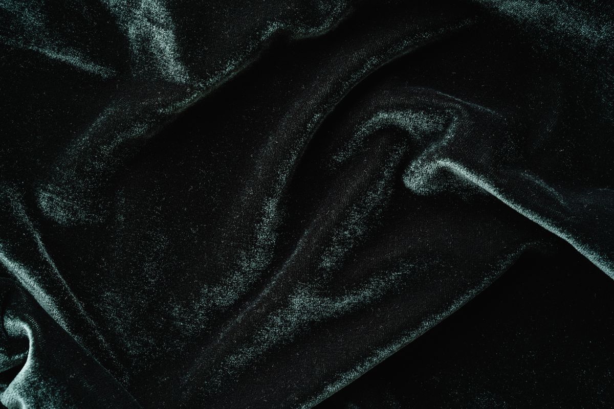 Gros plan sur un textile velours noir, la matière en relief caractéristique du flocage