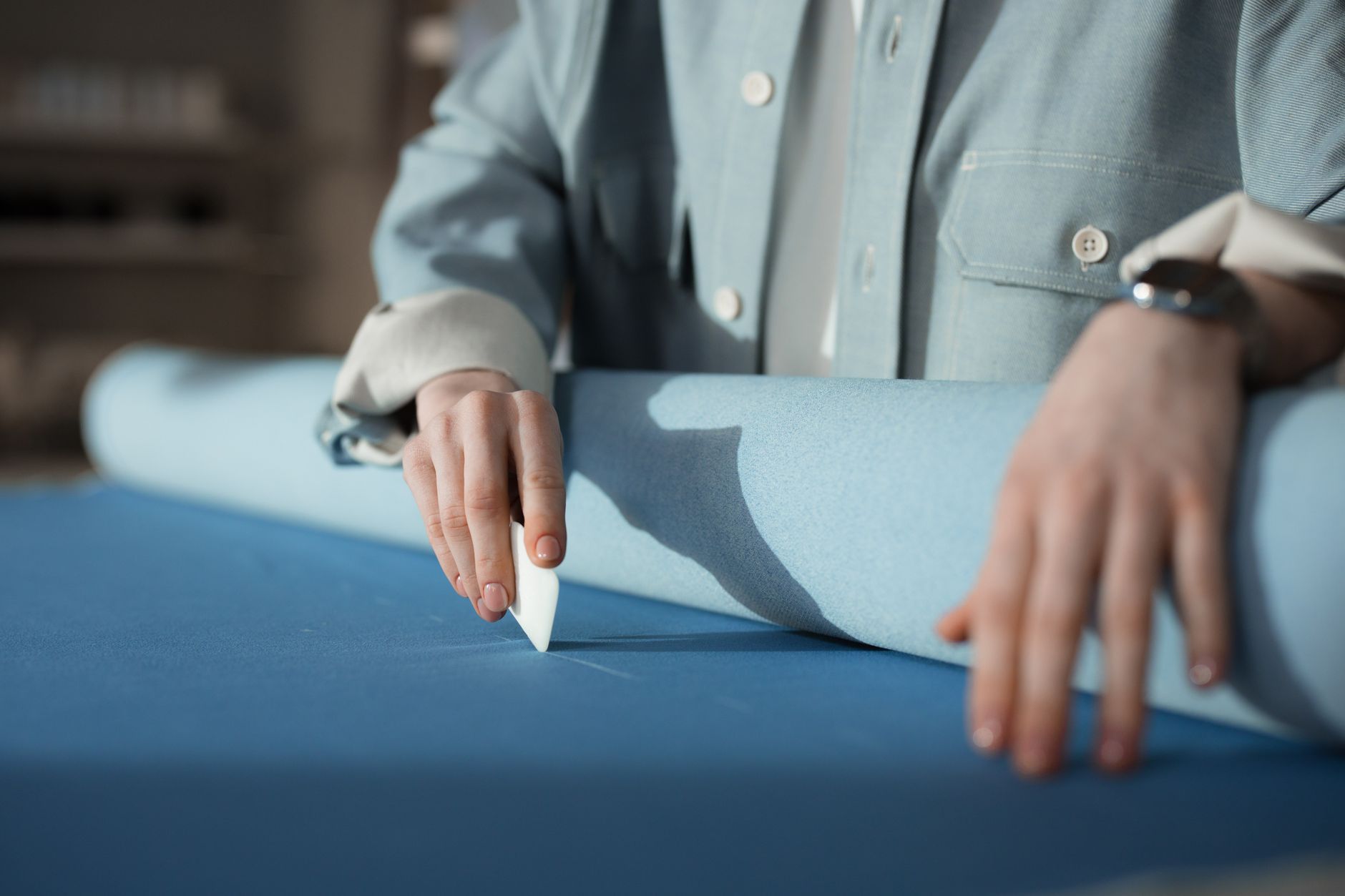Traçage à la craie sur un rouleau de tissu dans un atelier de personnalisation textile