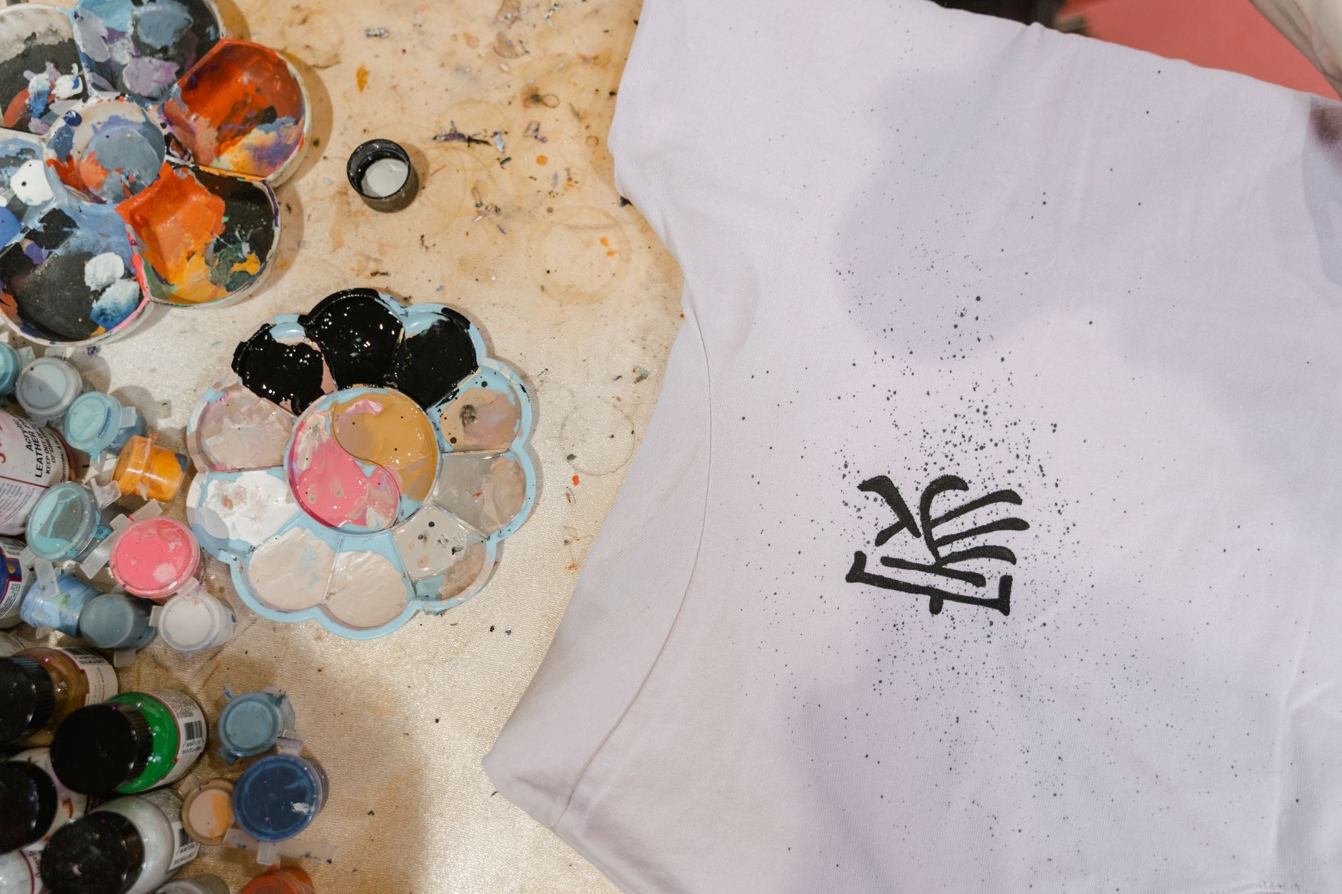 Créateur personnalisant un t-shirt d'équipe avec un transfert DTF à la presse à chaleur en atelier