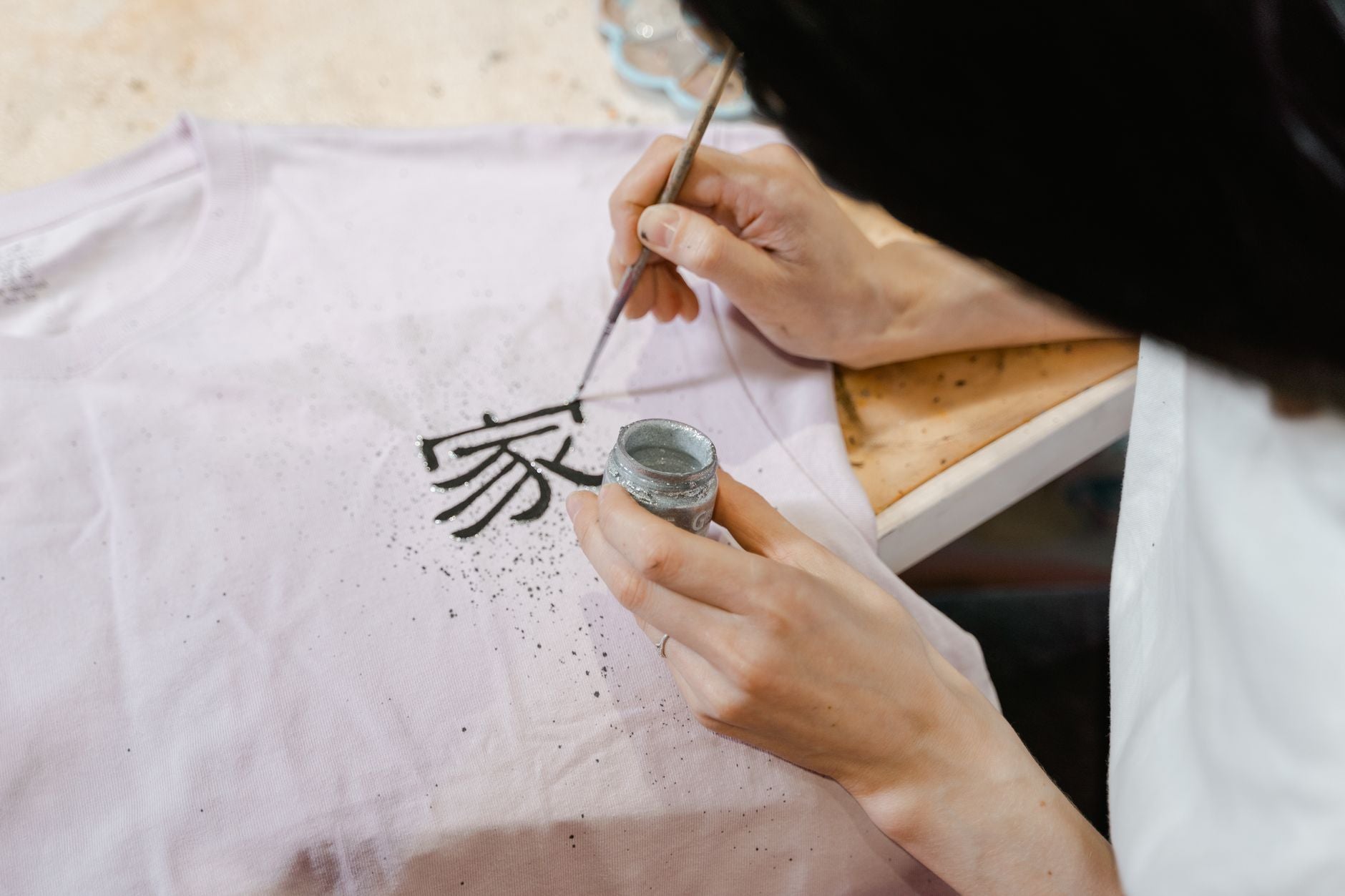 Créateur appliquant un transfert DTF sur un t-shirt avec une presse à chaleur professionnelle